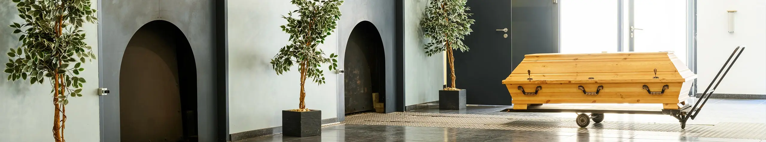 Holzsarg auf Rollwagen im Krematorium.